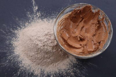 Picture of raw fresh pink Amazon Forest Pink Clay with bowl of wet clay for facial mask.