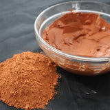 Picture of raw fresh red Amazon Forest Red Clay with bowl of wet clay for facial mask.