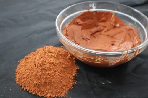 Picture of raw fresh red Amazon Forest Red Clay with bowl of wet clay for facial mask.