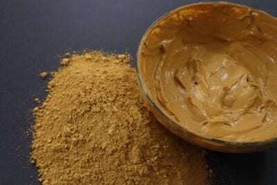 Picture of raw fresh yellow Amazon Forest Yellow Clay with bowl of wet clay for facial mask.